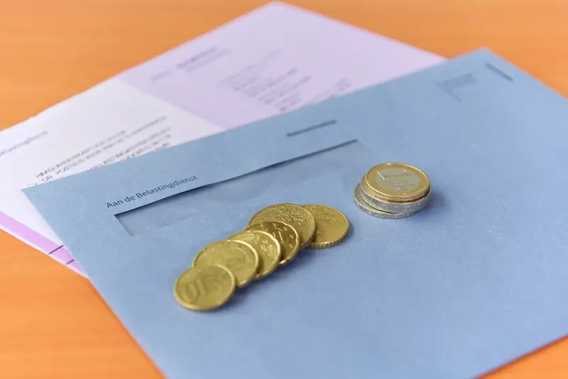 Brief van de Belastingdienst met een stapeltje munten