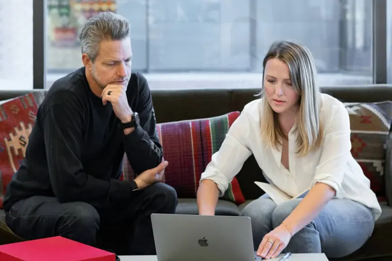 Ondernemers bespreken investeringen samen achter een laptop